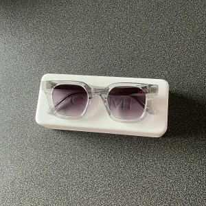 Transparenta solglasögon från CHIMI - Snygga solglasögon från CHIMI med transparent båge och fyrkantig form. Glasen är gråtonade och ger en modern vibe. Kommer med originalfodral, påse och putsduk. Perfekta för att lyfta din stil året runt.