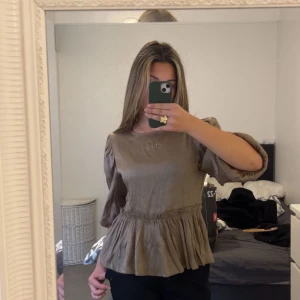 Beige blus med volang - Säljer en beige blus med volang nertill och puffiga långärmar. Passade längre inte med färgen personligt 