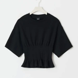 Svart topp - wide sleeve arms  - Säljer en svart  topp med rynkdetalj i midjan. Toppen har korta ärmar och rund halsringning. Har använt den 1-2 gånger. Kan skicka fler bild vid förfrågan!! Den är storlek M fast jag som är S passar jättebra i den.