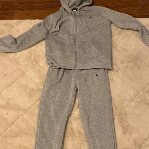 Grå mjukisbyxor från Polo Ralph Lauren - Säljer ett par grå mjukisbyxor från Polo Ralph Lauren med liten broderad logga på ena benet. Byxorna har en avslappnad passform och är perfekta för en chill dag hemma eller till träningen.