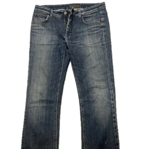 Blå jeansbyxor från Acne Jeans - Klassiska blå jeans från Acne Jeans med fem fickor och raka ben. Jeansen har normal passform och subtila slitningar framtill för en avslappnad look. Perfekta till vardags och lätta att matcha med olika stilar. Storlek 32/32. Ny pris 1800kr. Hör av dig vid frågor