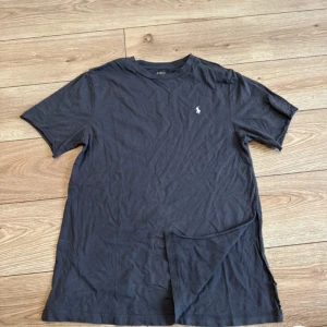  t-shirt från Polo Ralph Lauren -  t-shirt från Polo Ralph Lauren med klassisk broderad logga på bröstet. T-shirten har rund halsringning och korta ärmar. Perfekt för en stilren och enkel look. 