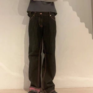 Svarta jeans med rosa detaljer 34/34 - Svarta jeansbyxor med rosa sömmar köpta i Japan. Storleken sägs vara XL men skulle uppskatta den till w34/L36 men man kan som ni ser vika upp bensluten om man vill så visas ett snyggt rutigt mönster likt det på bakfickorna.