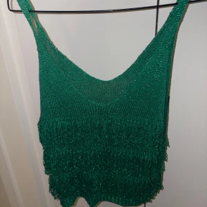 Glittrig topp med fransar grön - Såå söt och unik topp som glittrar med massa fransar på framsidan! Skitanygg! Köpt på en butik i Spanien för något år sen- använt 1-2 gånger så nyskick! Passar xs-m lätt: jag bär S-liten M. Självklart kan pris diskuteras 