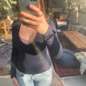 Mörkblå långärmad topp från Gina Tricot - Säljer en mörkblå långärmad topp från Gina Tricot med djup v-ringning. Toppens material är mjukt och stretchigt. Passformen är tight och den har en klassisk design utan mönster eller extra detaljer. Använt en gång 💕