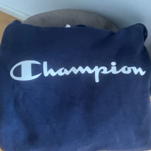 Mörkblå Champion hoodie med logga - En marinblå hoodie från champion. Använt 1 gång