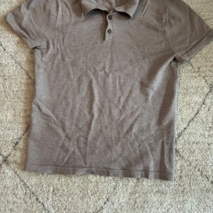 Beige pikétröja från John Henric - Säljer en stilren beige pikétröja från John Henric i storlek M. Tröjan har klassisk krage, tre knappar framtill och korta ärmar. Perfekt för en clean och avslappnad look. Materialet känns mjukt och andas bra.