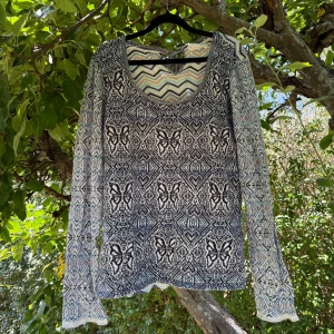 Mönstrad stickad tröja Odd Molly - Säljer en långärmad stickad tröja från Odd Molly med snyggt geometriskt och fjärilsmönster i blått, svart, vitt och inslag av ljusrosa och mint. Tröjan har rund hals och coola detaljer med zigzag-mönster upptill. Perfekt för dig som gillar unika plagg med boho-vibe. Storlek 4 som enligt deras storleksguide motsvarar en storlek L. Kan vara något liten i storlek. Fint skick, men den är något blekare än ny och något tvättpåverkad. 