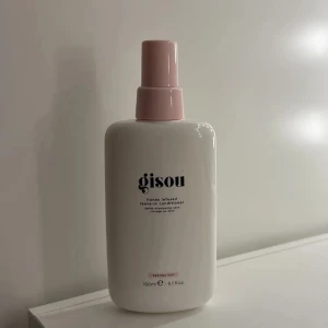 Gisou leave-in conditioner 150ml - Gisou honey infused leave-in conditioner i en stilren vit flaska med ljusrosa spraykork. Innehåller 150 ml och är perfekt för att ge håret extra fukt och glans. Snygg design som passar på badrumshyllan och doftar fräscht av honung.