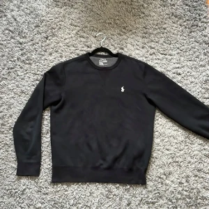 Svart Ralph Lauren tröja - Svart sweatshirt från Polo Ralph Lauren med rund hals och vit klassisk logga på bröstet. 