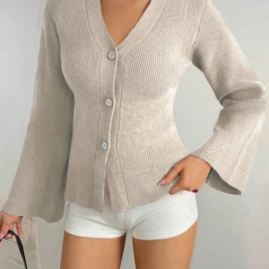 Beige stickad kofta med vida ärmar - En jättemysig kofta som passar till hösten💗 Koftan är väldigt skön och varm med tre enkla knäppningar. Den är i storlek S men skulle säga att den passar M också då den är väldigt stretchig. Säljer pga att den är för kort i armband på mig som är 174 då jag har längre armar.  Total längd: 63 cm (från nacken och neråt) Armlängd: 41 cm (från armhålan till handleden) Midjemått: 38 cm (mätt vid det smalaste stället rakt över, liggandes)  Skriv om frågor, pris kan diskuteras💗