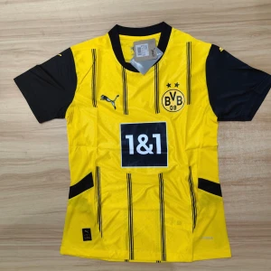 Borussia Dortmund Puma matchtröja M - Borussia Dortmunds officiella matchtröja från Puma i storlek M. Tröjan är gul med svarta vertikala ränder, svarta korta ärmar och svart krage. BVB-logga och Puma-logga på bröstet, samt sponsortryck 1&1. Materialet är lätt och andas, perfekt för fotboll. Sprillans kommer i förpackning
