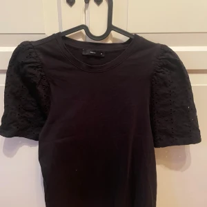 Svart blus med puffärm från only - Supersnygg svart blus från only med korta puffärmar i broderad bomull. Ärmarna har fina håldetaljer som ger en cool och trendig look. Perfekt för dig som vill ha något enkelt men ändå med det lilla extra.