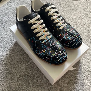 Maison Margiela – GAT  - Maison Margiela – GAT (storlek 43) 👟✨ Klassiska German Army Trainers från Maison Margiela – en tidlös sneakerikon! Tillverkade i premiumläder med mockadetaljer, minimalistisk design och grym komfort. Passar både till jeans och mer dressat 💎🔥  • Storlek: 43 (EU) • Skick: Mycket fint skick (se bilder) • Nypris: ca 4500 kr 💸  💡 Köpt från privatperson. Tidigare ägare visade kvitto och sa att de är äkta, men jag kan inte garantera det till 100 % – därav det låga priset.  Billigt pris pågrund av defek