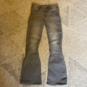 Grå bootcut jeans från Kappahl - Snygga grå jeans från Kappahl i storlek 152. Modellen har bootcut-ben. Jeansen är tillverkade i mjukt denimtyg.
