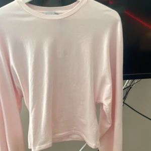 Ljusrosa långärmad tröja 157 S - Supermjuk och basic ljusrosa långärmad tröja från 157. Tillverkad i stretchig bomullsblandning med rund hals och enkel design. Perfekt att styla med jeans eller kjol för en clean look.