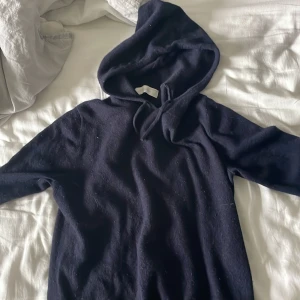 Mörkblå kashmirhoodie från Sayless - Mysig mörkblå hoodie från Sayless i lyxig kashmir. Tröjan har huva med snörning och långa ärmar, perfekt för dig som gillar en chill och stilren look. Enkel design utan mönster, supermjuk och skön mot huden. Mycket bra skick använd 1-2 gånger.