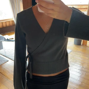 Grön omlottopp från Gina - Snygg mörkgrön omlottopp med v-ringning och långa ärmar. Toppen har ribbad nederkant och knyt i sidan för en extra detalj. Så mjuk och skön stickad känsla💓Använd ca 5 gånger, från Gina Young storlek 158/164 men passar mig som har S