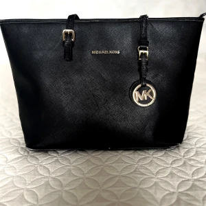 Michael Kors svart handväska  - Finns en del skavanker (skriv privat för fler bilder)  Fodret inuti har bland annat gått sönder i hörnen (ingenting som syns eller påverkar användningen) Även sömmarna till ena fickan inuti väskan har släppt  Annars är det bara småskavanker efter en tids användning 💗  Mått:  Längd: ≈ 42cm  Djup: ≈ 28cm 