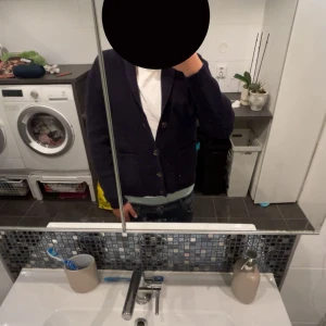 Mörkblå kofta från Pier One - Snygg mörkblå kofta från Pier One med ribbad struktur, knappar framtill och två fickor. Koftan har en klassisk krage och är långärmad, perfekt för lager-på-lager-stil. Passar dig som gillar en clean och stilren look.