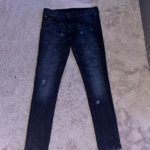 Mörkblå slim fit jeans Polo Ralph Lauren - Snygga mörkblå slim fit jeans från Polo Ralph Lauren med slitna detaljer och klassisk femficksdesign. Jeansen har en smal passform och är tillverkade i stretchig denim för extra komfort. Perfekta för dig som gillar en trendig och avslappnad look. Har gjort slitningarna själv. Jeansen är aldrig använda och skriv dm ifall ni har några funderingar.