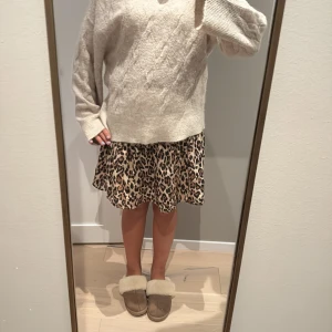 Leopardmönstrad kortkjol Gina Tricot - Säljer en kort kjol från Gina Tricot med leopardmönster i beige och bruna toner. Kjolen har volangkant och är tillverkad i ett lätt, luftigt material som ger en skön och flowy känsla. Perfekt för dig som gillar djurmönster och vill sticka ut.