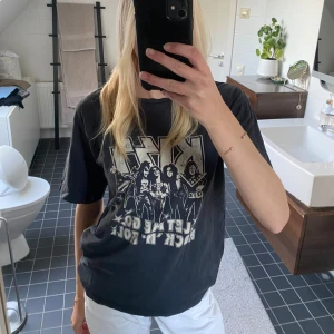 KISS band-tshirt - Svart t-shirt med stort KISS-tryck och texten 'Let Me Go, Rock 'N Roll' på framsidan. Oversized passform och korta ärmar.