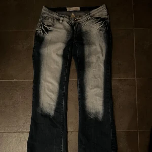 bootcut jeans med design pop fickorna  - Säljer ett par bootcut jeans med snygga detaljer bak. Jeansen har låg midja och är bootcut. skriv för mått 