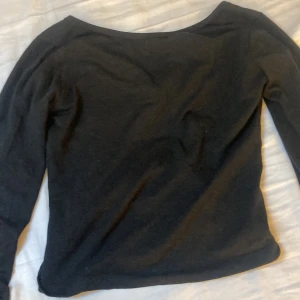 Svart långärmad topp med rund hals - En enkel svart långärmad topp med rundad halsringning. Perfekt basplagg som funkar till många olika outfits. Mjuk och skön, passar året runt.  Tröjan har öppen rygg till viss del och är från Gina tricot.
