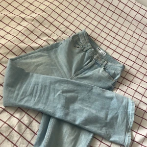 Ljusblå bootcut jeans från Bershka  - Säljer ett par ljusblå jeans från Bershka med klassisk femficksdesign och bootcut-ben. Jeansen har hög midja och är tillverkade i mjukt denimtyg. Perfekta för en avslappnad och trendig look. Aldrig använda. 