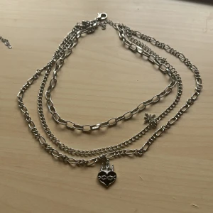 halsband med berlocker - Säljer då den inte kommer till användning, vet inte vilket metall den är gjord av tyvärr 