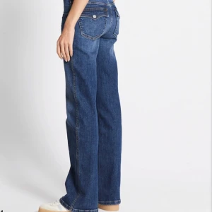 Blå bootcut jeans - Snygga blå bootcut jeans med klassisk femficksdesign och kopparfärgade nitar. Jeansen har normal passform och är tillverkade i ett tåligt denimtyg. Perfekta för en avslappnad och trendig look. Lager 157 90s bootcut. Aldrig använda 