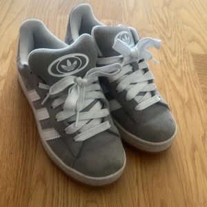 Grå Adidas sneakers med vita ränder - Knappt använda, bara några fåtal gånger. Storlek 38