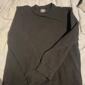 Svart långärmad tröja från H&M - En enkel svart långärmad tröja från H&M med regular fit. Tröjan har ribbade muddar. Perfekt basplagg för garderoben och en vanlig men snygg look! Hör av er vid funderingar.