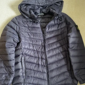 Stone Island jacka - En bra allvädersjacka som också är av märket Stone Island, den har 1 fimphål på utsidan och 2 insidan. Färgen på jackan är mörkblå, Man kan ta av och sätta på luvan det kan man bestämma själv. Hör gärna av er vid frågor eller intresse!!