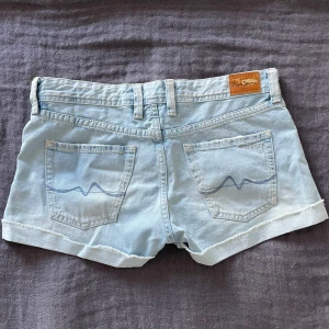 Lågmidjade jeansshorts  - Somriga och snygga jeansshorts med låg midja i ljus blått från Pepe Jeans. Materialet är lite åt det stretchiga hållet. De passar de med både S och M, S om man vill ha lite lösa och M lite tightare passform!