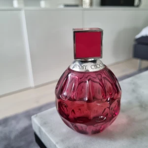 Jimmy Choo Exotic Eau de Toilette 60ml - Snygg parfym från Jimmy Choo i en lyxig, rundad glasflaska med djuprosa färg och silverdetaljer. Flaskan rymmer 60 ml och har en cool fyrkantig kork i matchande rosa. Perfekt för dig som gillar trendiga och eleganta dofter.