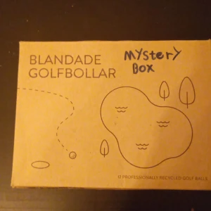 Blandade Golfbollar Mystery Box - Upptäck spänningen med en mystery box fylld med 12 professionellt återvunna golfbollar! Perfekt för dig som gillar sport, överraskningar och att testa nya saker på golfbanan. En rolig och miljövänlig present till dig själv eller en vän.