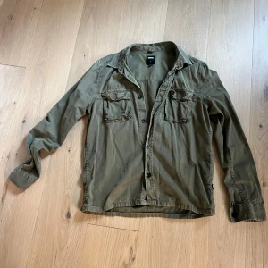 Skjortor Dr Denim och Zara - Fin militärgrön skjorta från Dr Denim i stl S. Aldrig använd, 100:-  Blå tunn skjorta i lite lättare skrynkligt material och murarkrage. Stl M. Skjorta är hela och rena, finns på Södermalm I Stockholm 