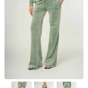 Jucy cutor mjukisbyxor med vida ben - Snygga gröna mjukisbyxor i mjuk velour med breda, vida ben och stora fickor fram och bak. Byxorna har dragsko i midjan för skön passform och en chill vibe. Perfekta för en avslappnad look.