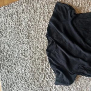 Svart t-shirt från Heron  -  Storleken kan passa mindre så skriv om ni har frågor Svart t-shirt från Heron i storlek XL. Klassisk rund hals och korta ärmar, tillverkad i mjuk bomull. Enkel och clean design som funkar till allt, perfekt för dig som gillar basic plagg med skön passform.