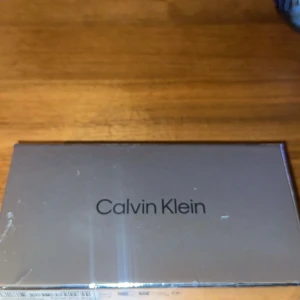 Calvin Klein parfymset miniatyr - Snyggt parfymset från Calvin Klein med fyra miniatyrflaskor: Eternity, Obsession, CK One och en smidig roll-on. Flaskorna har olika former och färger, från transparent till frostat glas och orange toner. Perfekt för dig som vill testa flera dofter från ett ikoniskt märke.