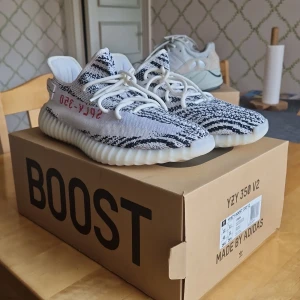 Yeezy 350 zebra oanvända - Köpta i butik från https://thesneakerstore.se för ett år sedan. Har bara stått på en Hylla (aldrig använda). Lappen som satt på dom finns kvar men är avklippt. 