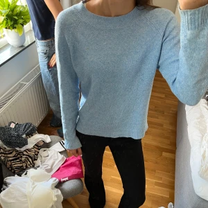 Ljusblå stickad tröja - Mysig ljusblå stickad tröja med rund halsringning och långa ärmar. Tröjan har en enkel och stilren design med ribbade muddar vid ärmslut och nederkant. Perfekt att slänga på sig när det är lite kyligare ute.