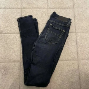 Mörkblå skinny jeans - Snygga mörkblå jeans med smal passform och klassiska fickor bak. Jeansen har en stilren look och är perfekta till en avslappnad outfit. Tillverkade i mjukt denimtyg för skön känsla hela dagen.