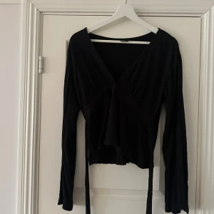 Svart omlottopp med långa ärmar - Svart omlottopp med v-ringning och långa ärmar. 🥰