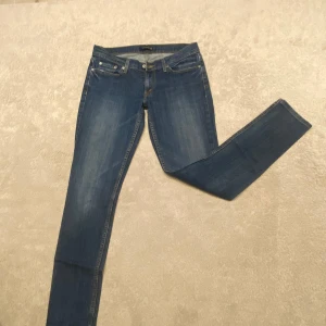 Levi's 524 Too Superlow jeans - Snygga blå Levi's 524 Too Superlow jeans med låg midja och skinny fit. Klassisk femficksmodell med gul kontrastsöm och diskret slitning på låren. Perfekta för dig som gillar en tight och modern look. Tillverkade i mjukt denimtyg.
