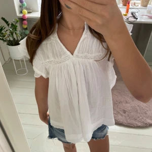 Vit blus med volangärm och spets - Superfin vit blus med v-ringning, volangärmar och spetsdetaljer. Luftig och lätt i bomull. Den har en lös passform och romantiska detaljer som ger en söt och trendig look. Passar xxs i dam. Aldrig använd🥰 pris kan diskuteras!