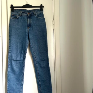 Rodebjer jeans  - Klassiska blå jeans med rak passform och hög midja. Jeansen har fem fickor, knappgylf och är tillverkade i slitstarkt bomullsjeansmaterial. Perfekta för dig som gillar tidlös stil och vill ha ett par jeans som funkar till allt. Modell Susan, storlek 25 