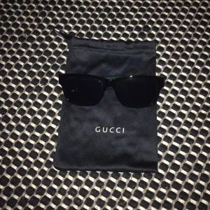 Glasögon  - Säljer G,u,cc,i glasögon. Glasögonen är svarta på framsidan och sen gröna och röda ränder på sidan och litet märke på höger sidan av glaset. Glasögon är i jättebra skick, köptes förra året. Pris kan självklart diskuteras.